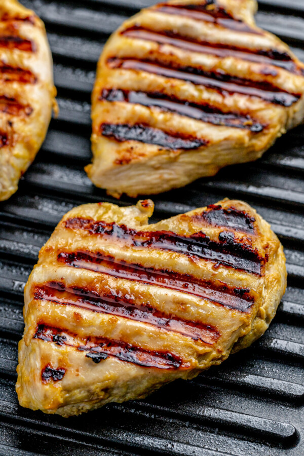 Chicken breast cooking on a grill.