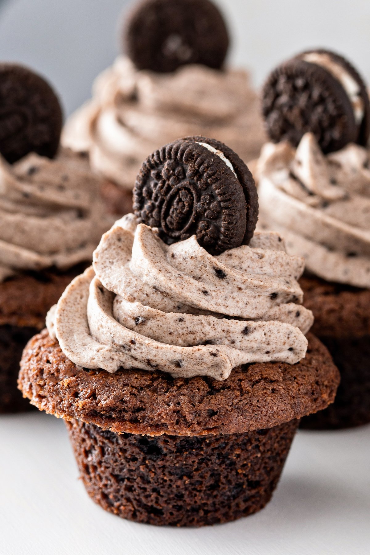 A chocolate cup filled with oreo filling and topped with a mini oreo cookie.