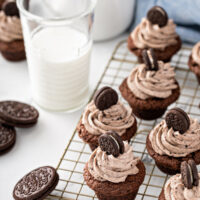 Oreo cheesecake desserts on a wire cooling rack next to a glass of milk.
