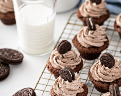 Oreo cheesecake desserts on a wire cooling rack next to a glass of milk.