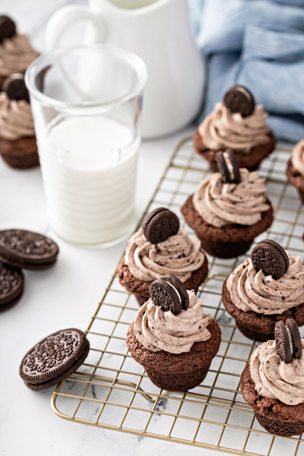 Oreo cheesecake desserts on a wire cooling rack next to a glass of milk.
