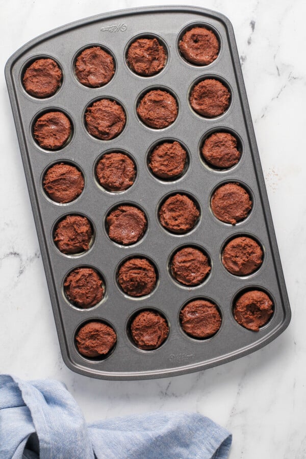 A mini muffin tin filled with cookie dough.