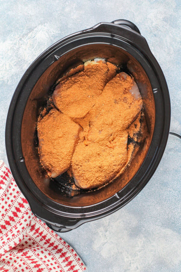 Seasoned chicken breast in a crockpot.