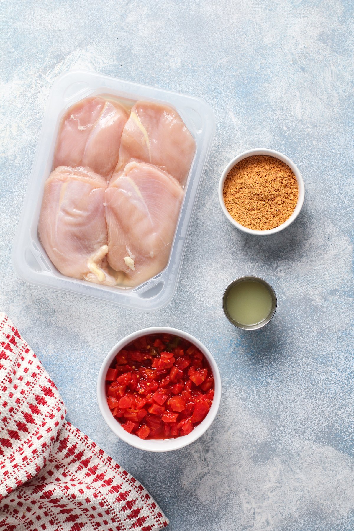 From top left: Raw chicken breasts, taco seasoning, lime juice, canned rotel tomatoes.