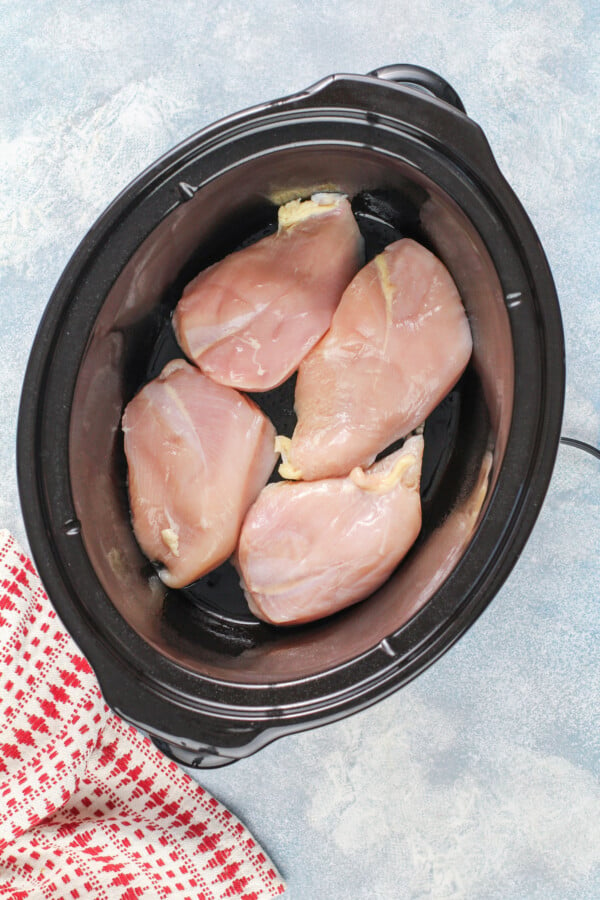 Raw chicken breasts in a crockpot.