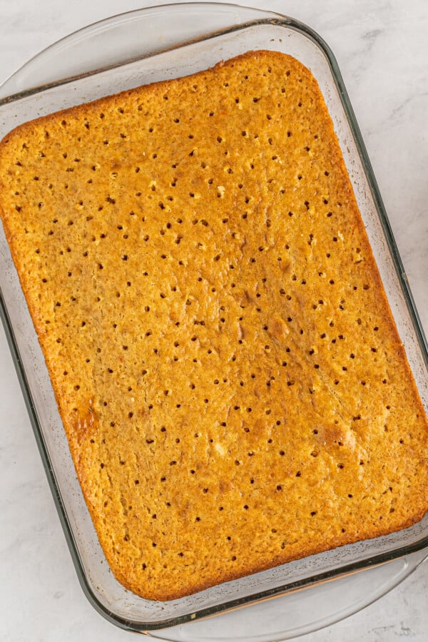A sheet cake with dozens of holes poked into it.