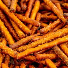 Honey mustard pretzels stacked on a cookie sheet.