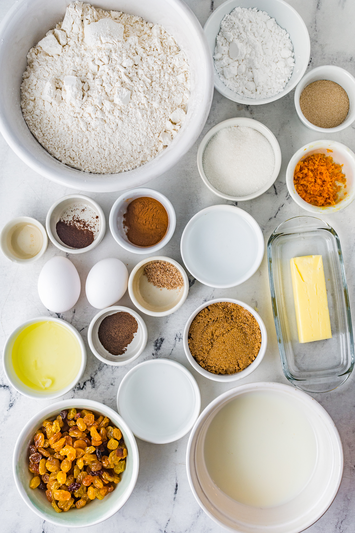 From top left: Flour, confectioner's sugar, yeast, granulated sugar, orange zest, vanilla, allspice, cinnamon, milk, butter, eggs, allspice, brown sugar, golden raisins, rum, water.