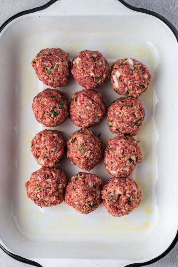 Raw meatballs in a baking dish.