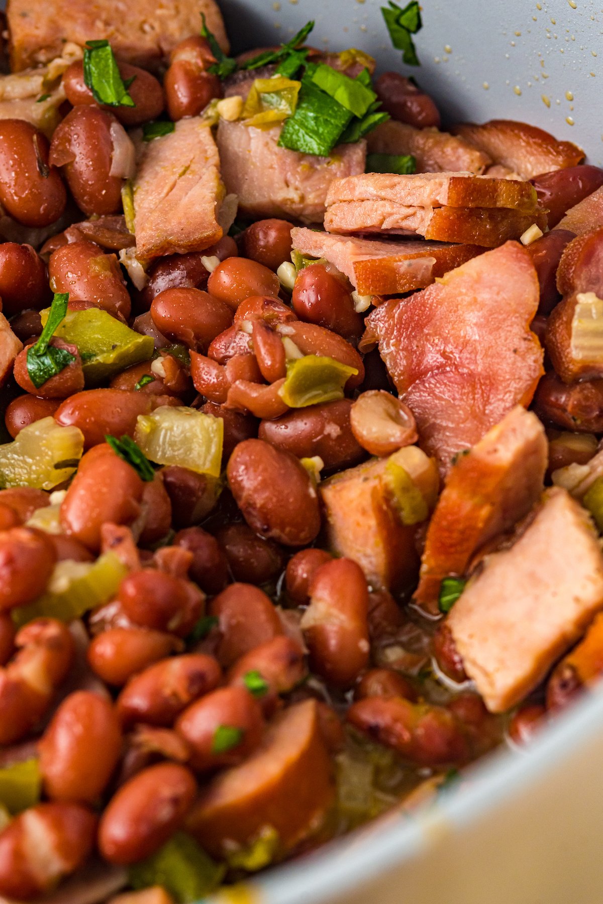 Cooked red beans with ham, vegetables, and sausage.