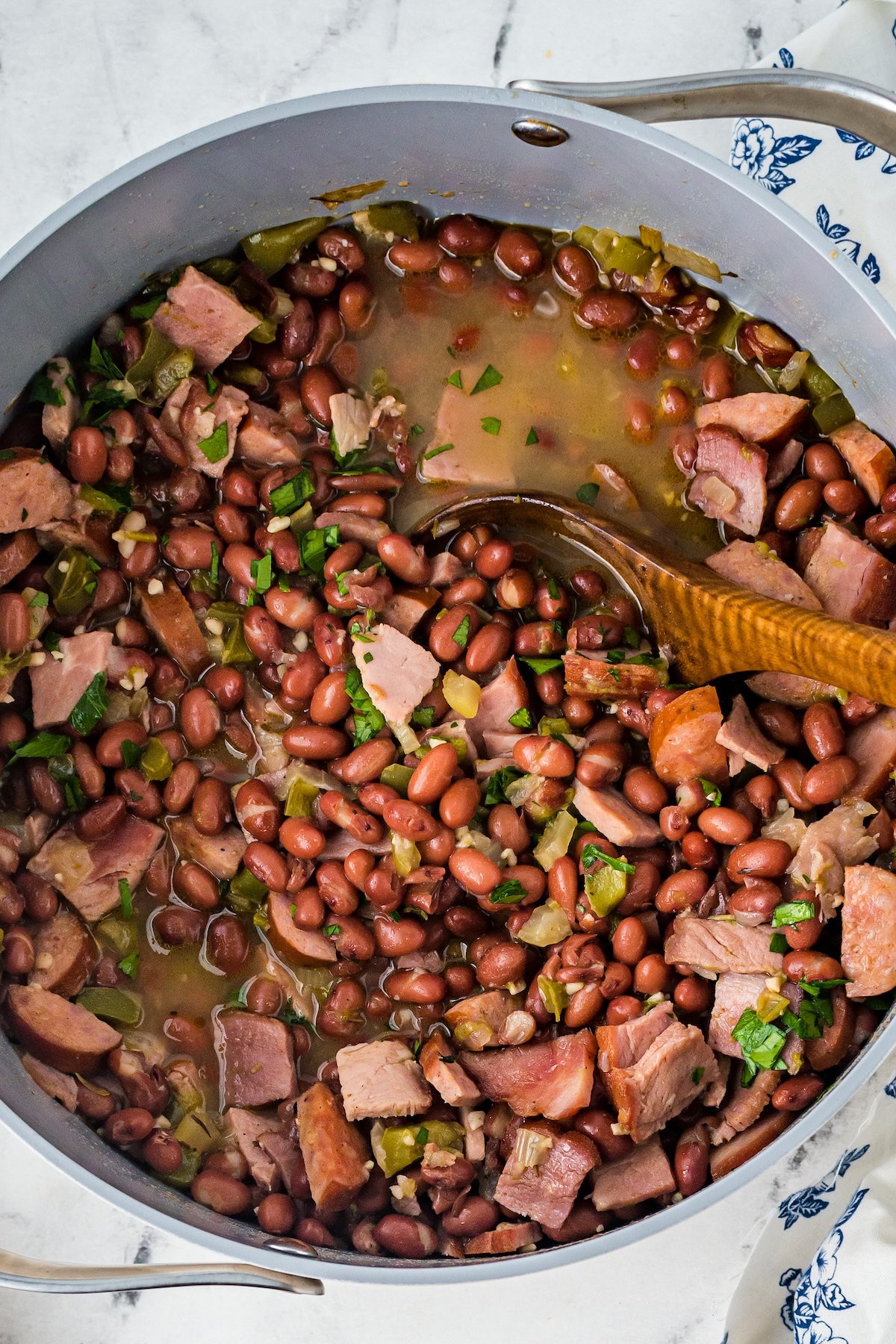 Red beans, ham, vegetables, and broth cooking in a large pot.