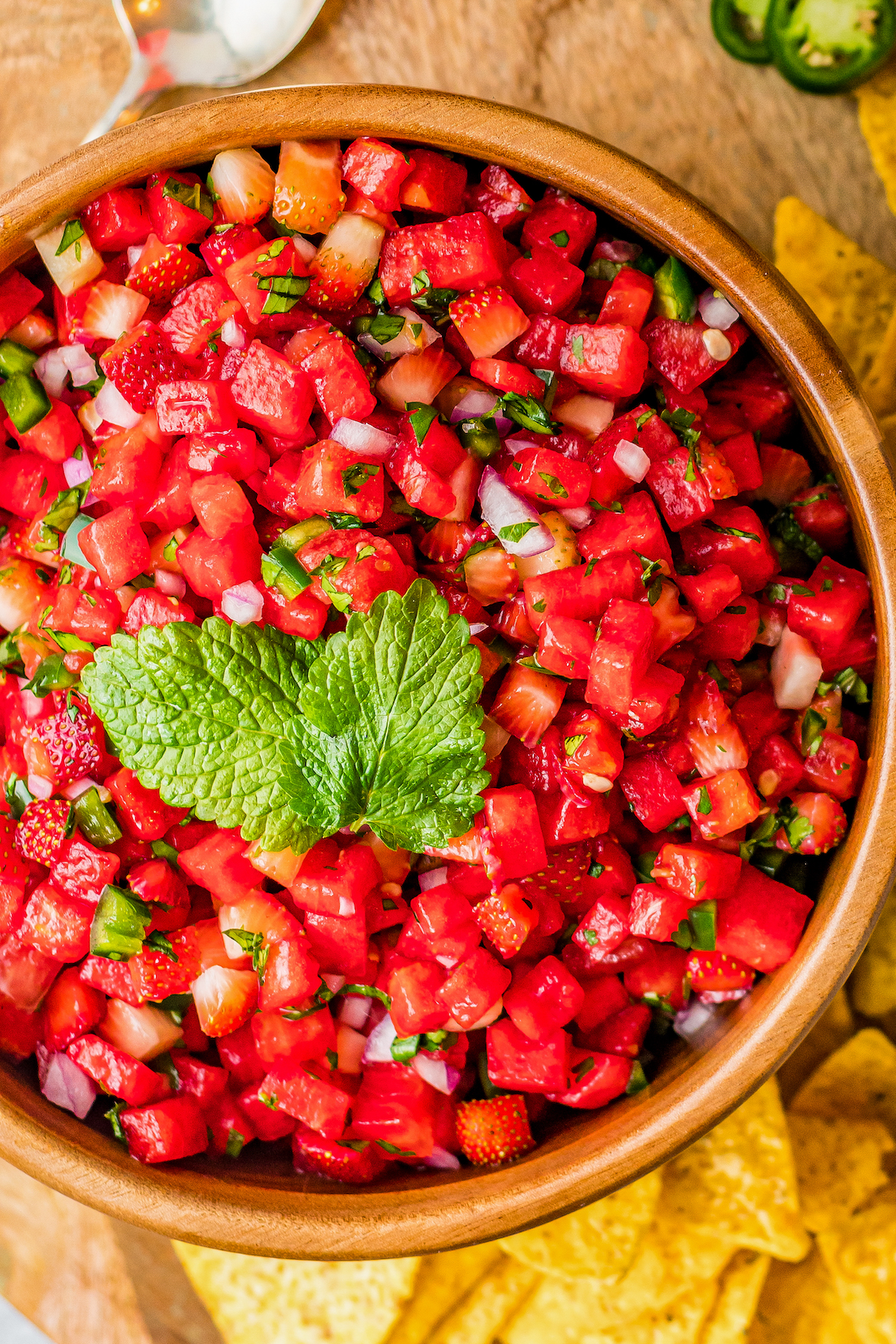 Overhead shot of a serving dish of salsa surrounded by chips.