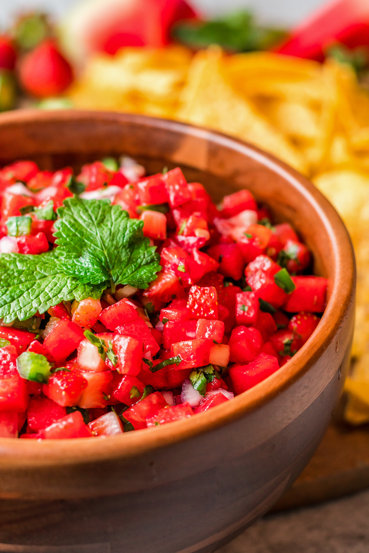 Salsa in a brown bowl, garnished with fresh mint.