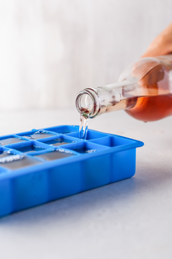 Wine being poured into an ice cube tray.