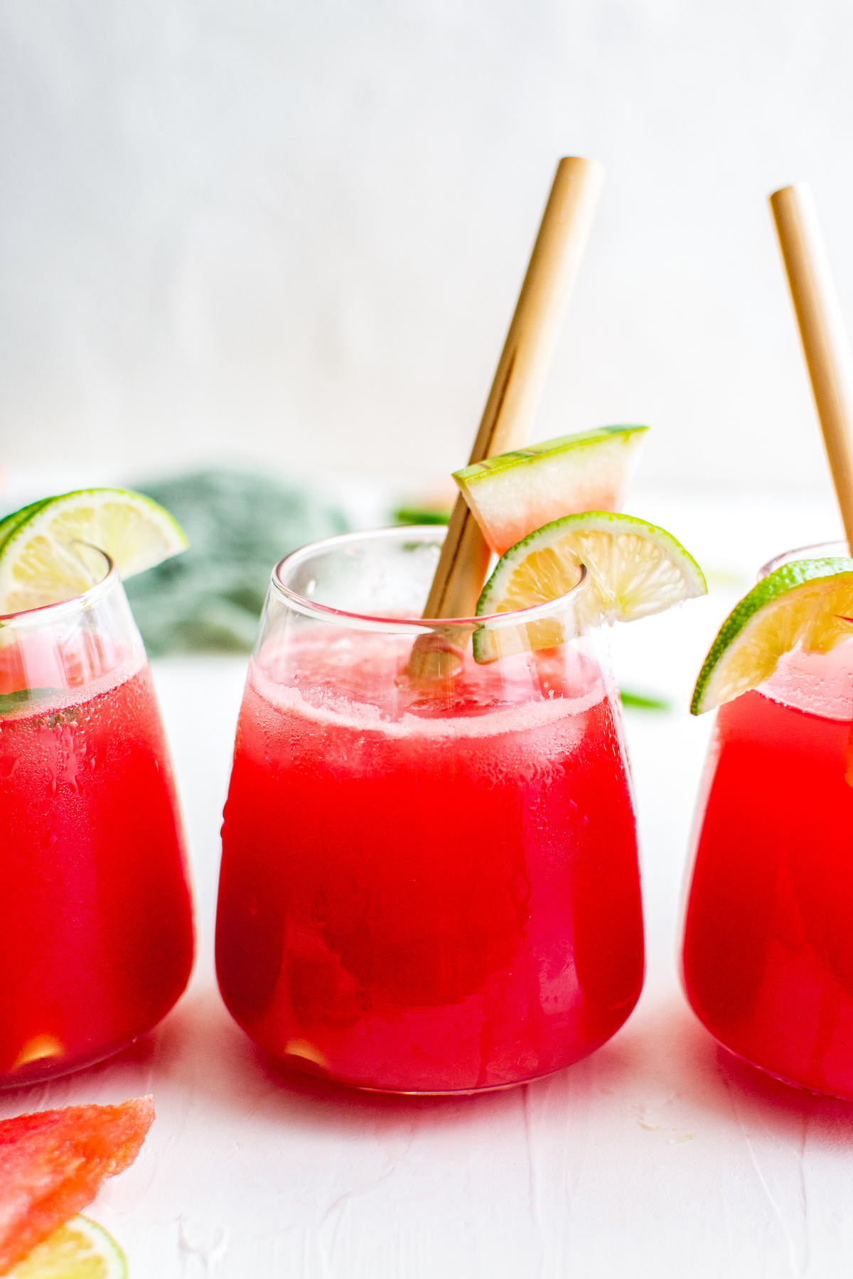 Three watermelon margaritas in rocks glasses on a white background.