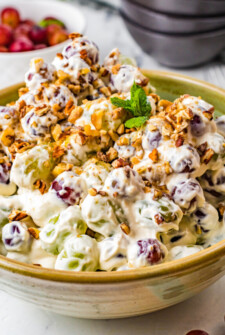 Side view of a large bowl of creamy fruit salad.