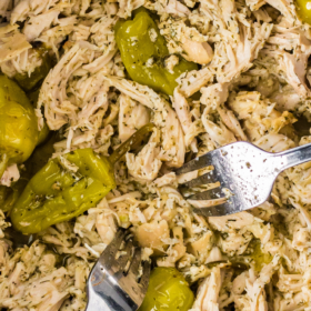 Mississippi Chicken in a crockpot being shredded with two forks.
