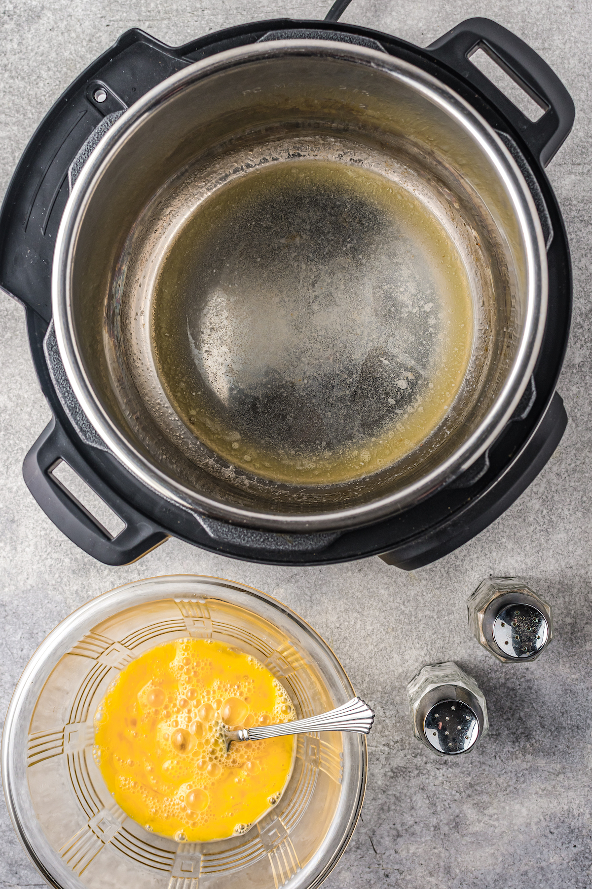 Whisked eggs in a bowl next to an empty Instant Pot.