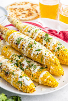 Mexican Street Corn on a white plate with cilantro sprinkled on top.