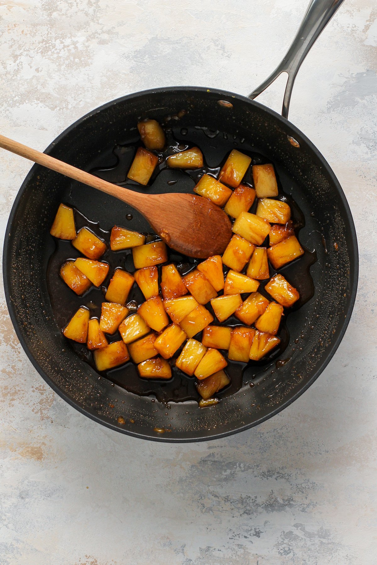 Pineapple chunks cooking in a skillet.