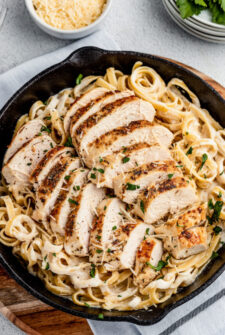 Overhead shot of a cast-iron skillet with pasta and chicken.