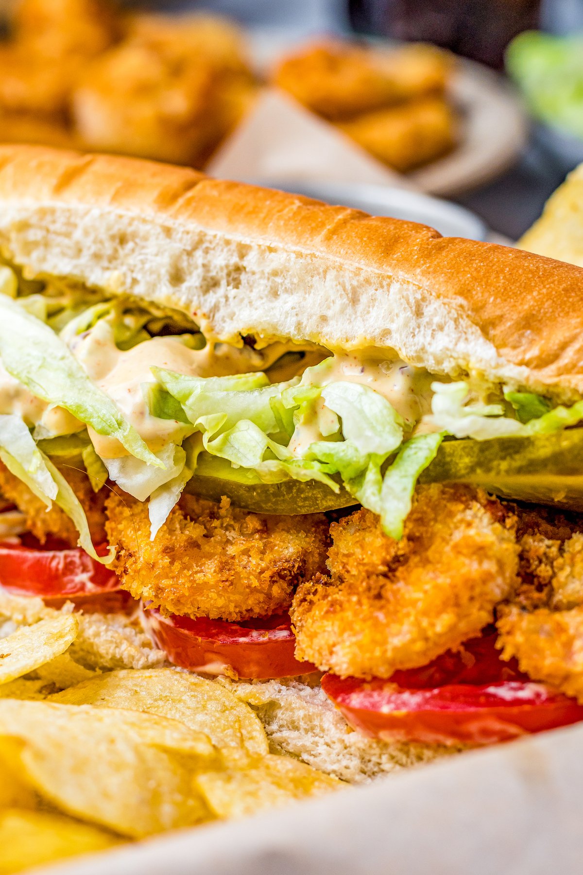 A shrimp sandwich with lettuce and tomato.