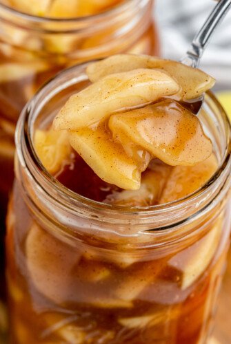 An open mason jar filled with apple pie filling.