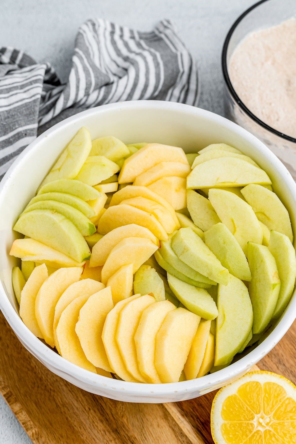 Peeled and cut apple slices in a white bowl.