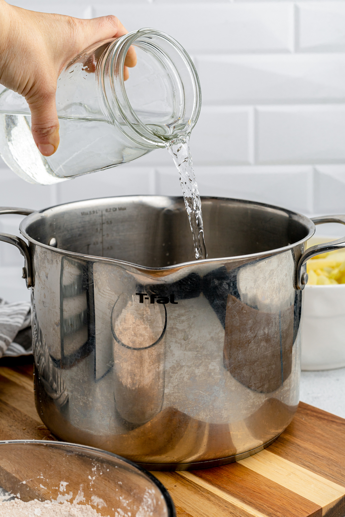 Water is poured into a large metal pot.