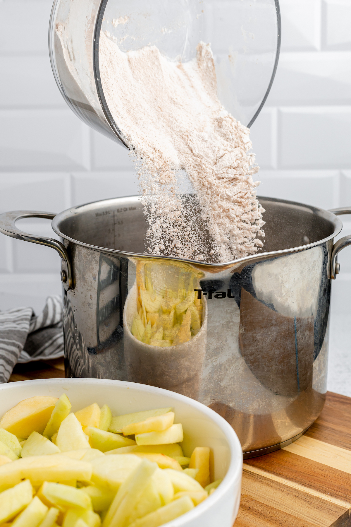 The cornstarch mixture is poured into a large metal pot.