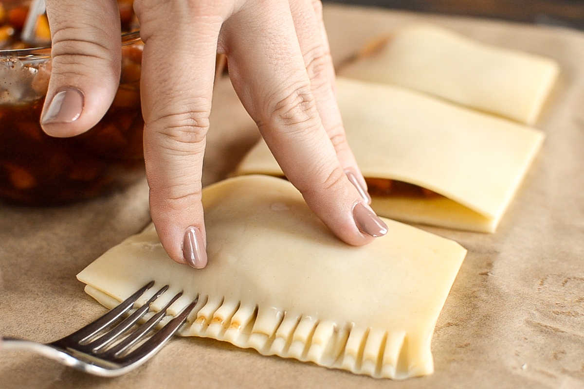 Homemade poptart edges being sealed together with a fork.