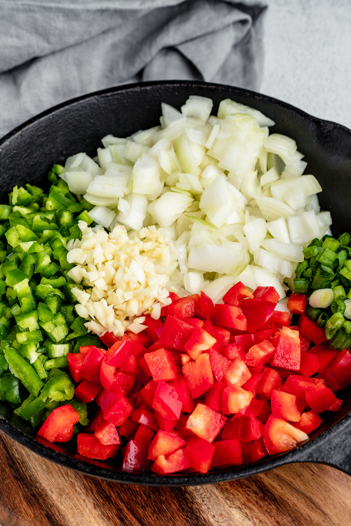 Onions, jalapenos, red peppers, and green onions in a large skillet.