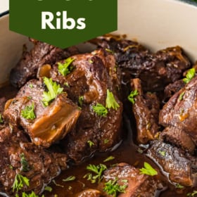 Beef short ribs in a dutch oven in a brown sauce.