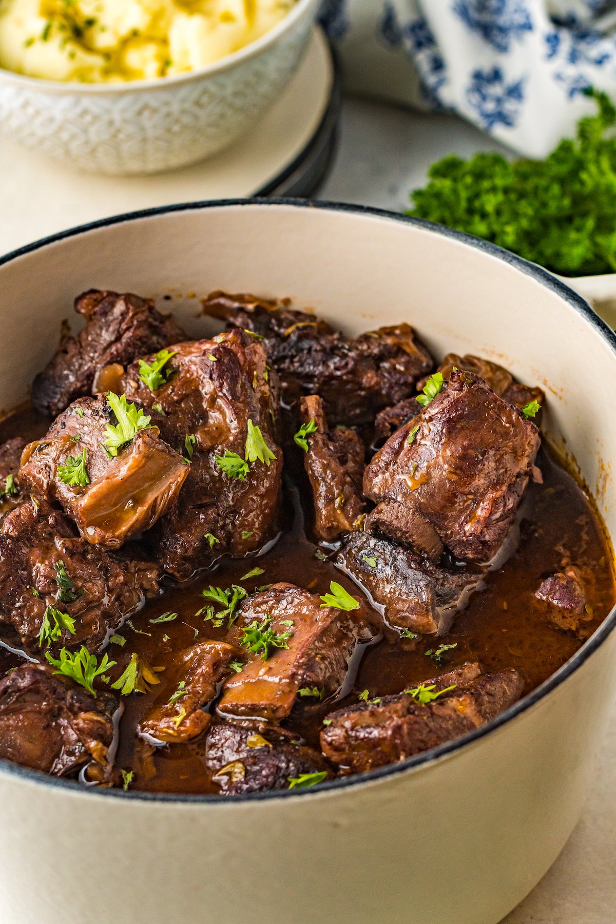 Braised Short Ribs in a dutch oven with parsley on top.
