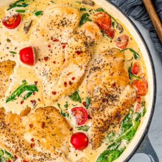 A skillet of Chicken Florentine with fresh cherry tomatoes.
