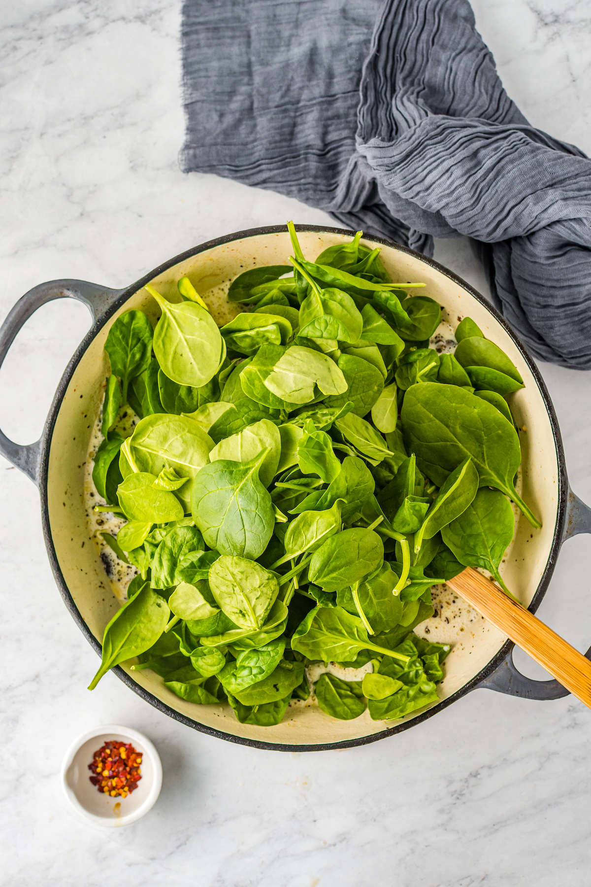 Spinach heaped into a skillet.