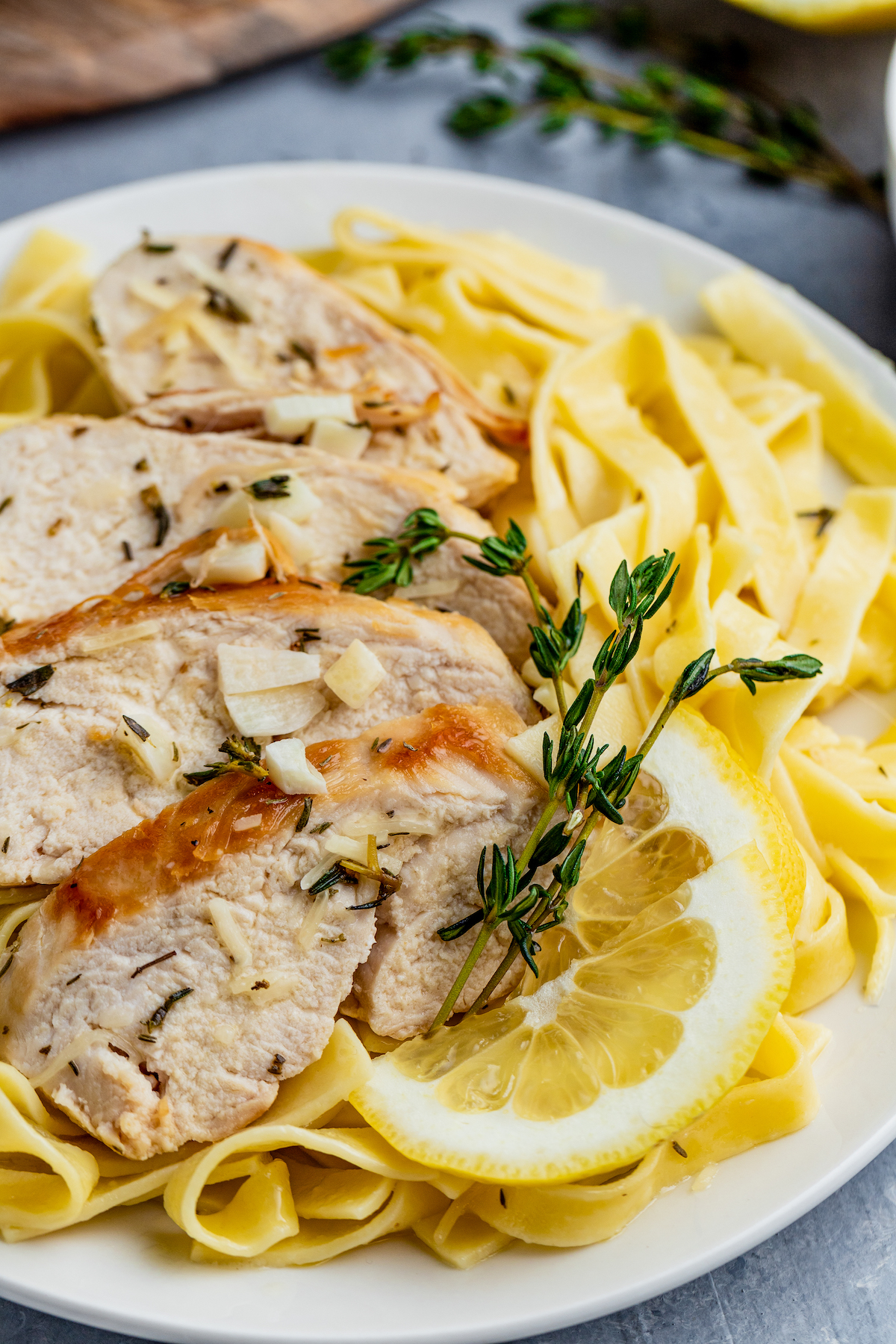 Lemon thyme chicken and pasta served on a plate.