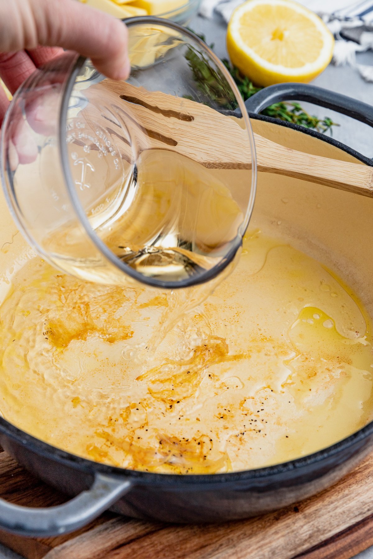 Wine is added into a skillet to deglaze chicken drippings.