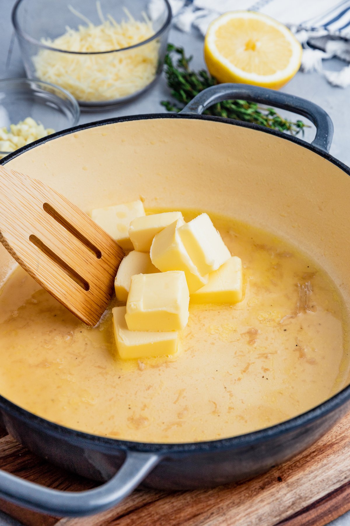 Butter melts in a skillet, stirred with a wooden spatula.