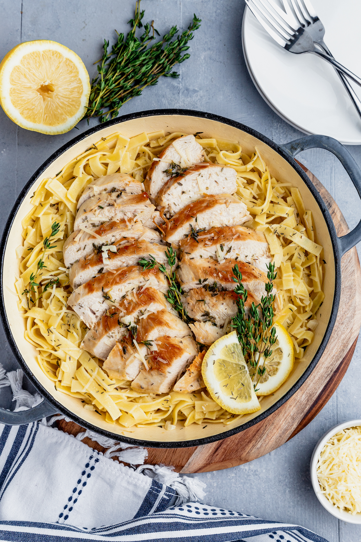 Sliced chicken served over a plate of pasta tossed in a lemon white wine sauce.