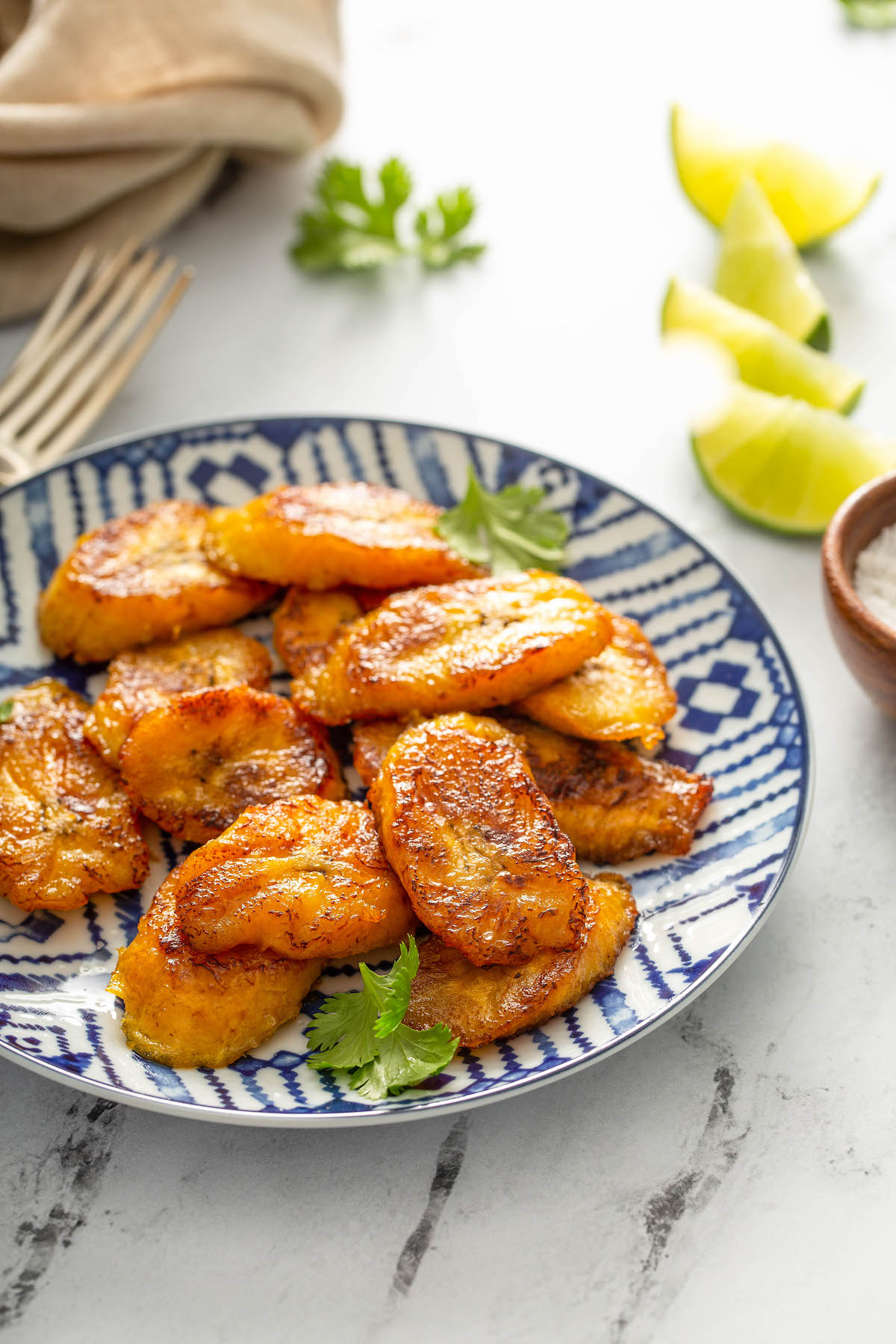 Sweet plantains in a blue bowl with cilantro.