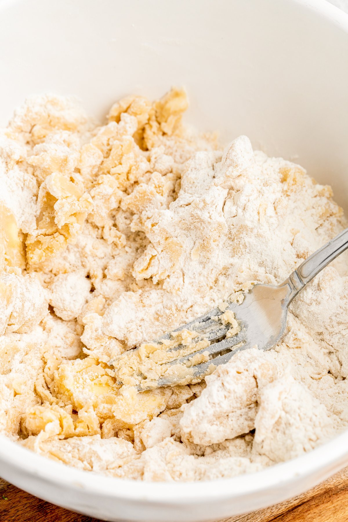 A fork is used to cut butter cubes into flour.