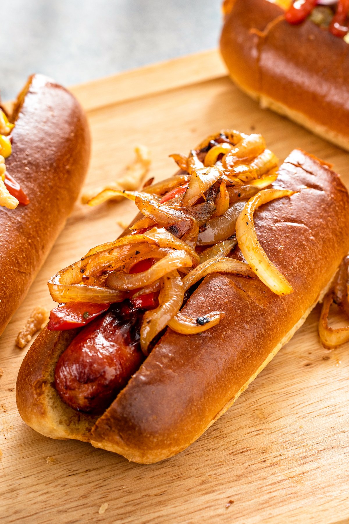 Close up of an air fryer hot dog in a bun, garnished with caramelized onions.