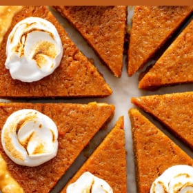 A pie sliced into pieces on a cutting board.