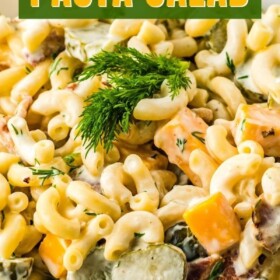 Pickle pasta salad in a white bowl with fresh herbs on top.