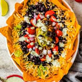 Overhead shot of a taco salad with rings of chips, cheese, olives, tomatoes, and more.