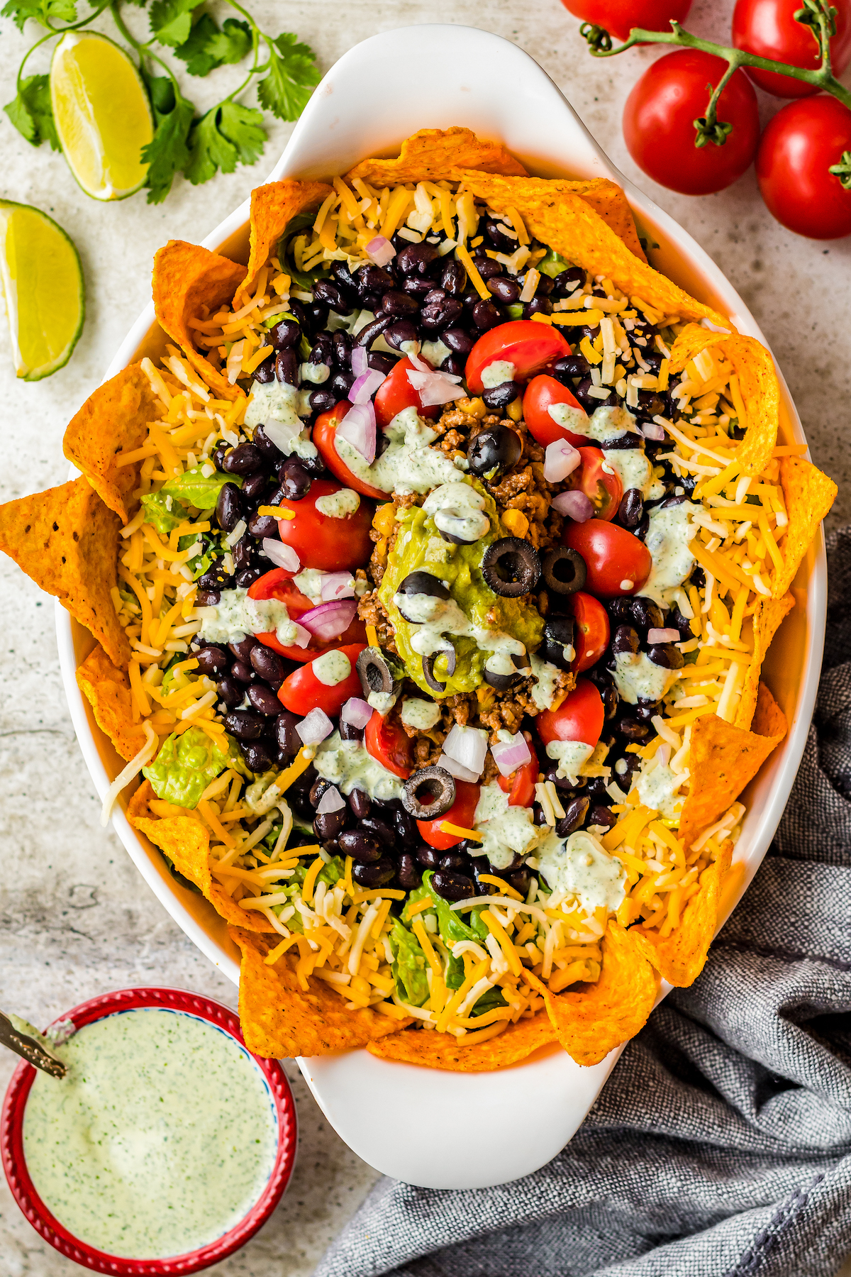 Overhead shot of a taco salad with rings of chips, cheese, olives, tomatoes, and more.
