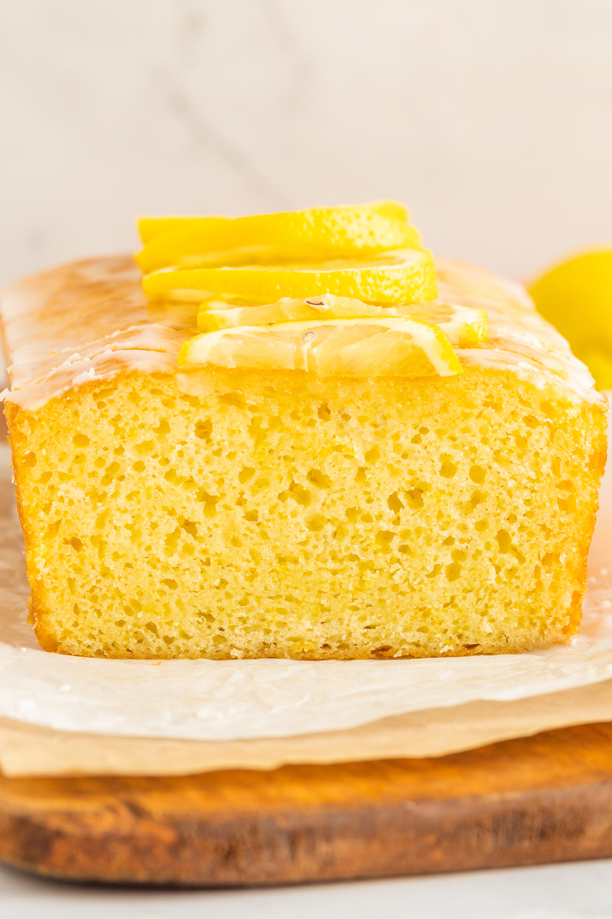 Side view of a cut lemon loaf cake, showing the interior texture of the crumb.