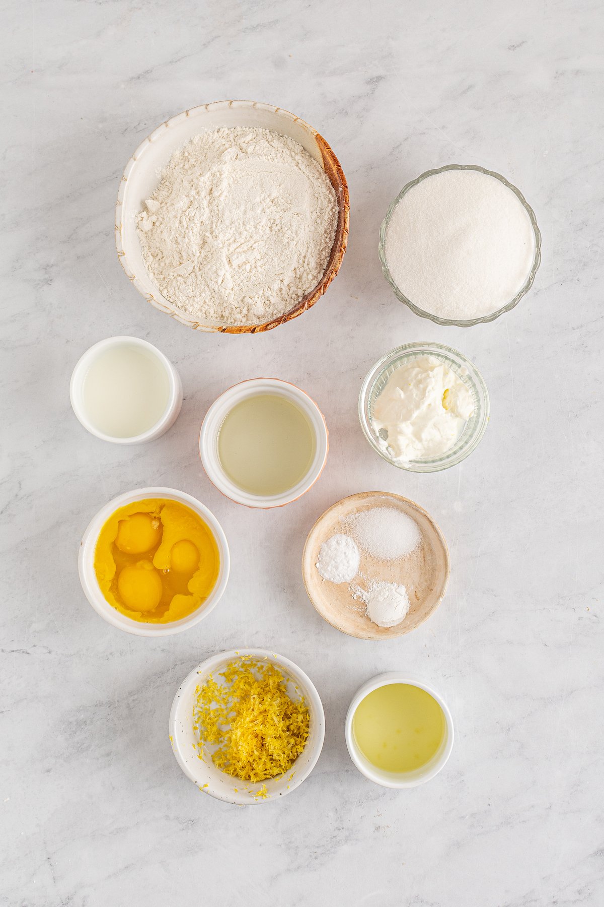From top left: Flour, white sugar, milk, oil, sour cream, eggs, baking powder, baking soda, salt, lemon zest, lemon juice.