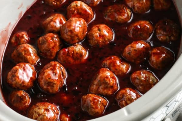 Easy 3-ingredient Grape Jelly Meatballs made in the crockpot or on the stovetop. Sweet, savory, and gone in minutes at every party! Crockpot meatballs coated in a glossy, thick bbq and grape jelly sauce sit in a white slow cooker.